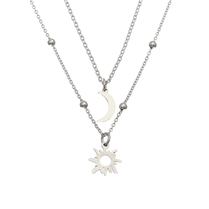 Detail showing silver double-layered necklace with sun and moon pendants on white base