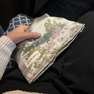 Satin floral makeup bag in light green with pink flower patterns and brand label