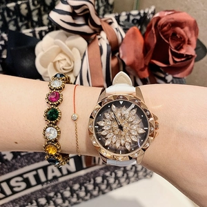 Close-up of women's rose gold watch with sparkling sunflower dial and white leather strap