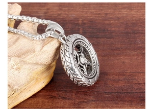 Macro shot of tire-shaped titanium steel pendant with Roman numerals and box chain