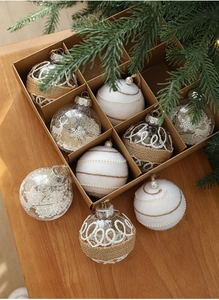 Detail of diverse 8cm Christmas balls with rustic twine and white fur in a gift box