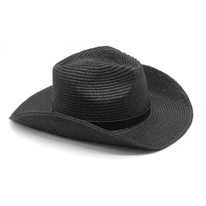 Detail of classic black woven straw cowboy hat with curved brim and textured finish