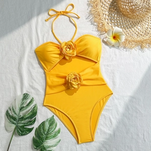 Detail of yellow halter swimsuit featuring decorative 3D roses and cutout design