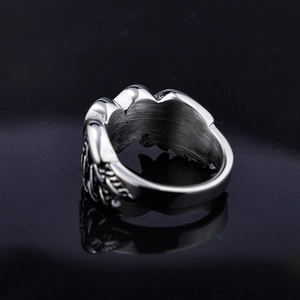 Macro detail of silver feather ring showing inner brushed texture and side relief carving
