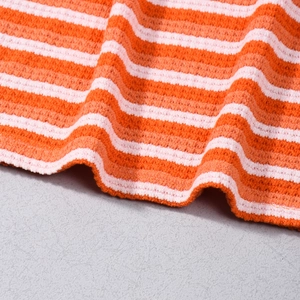 Detailed close-up of orange and pink striped waffle knit fabric showing soft texture