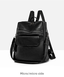 Detailed side view of black PU leather backpack showing zip pockets and soft pebbled texture
