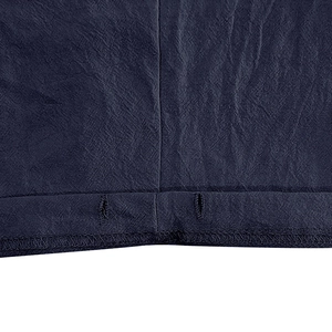 Detailed close-up of dark blue linen shorts fabric texture and reinforced double stitching