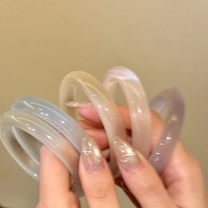 Close-up of translucent candy-colored resin bracelets in soft pastel jelly tones