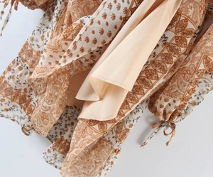 Detail of bohemian dress sleeve with paisley floral print and drawstring cuff