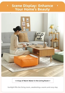 Close-up of square floor cushions with cross-stitch design in orange and cream faux leather