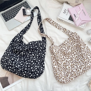 Flat lay of high-capacity leopard print canvas bags in black and beige with lifestyle props