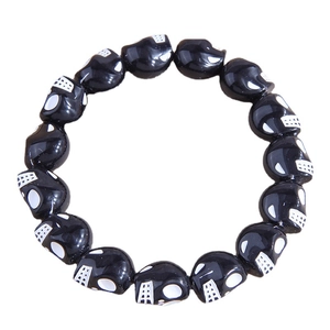 Fashionable black beaded bracelet with skull patterns on a clean white background