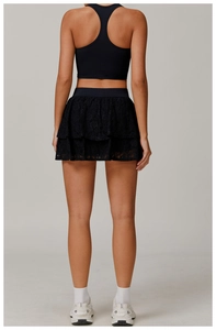 Detailed view of black layered lace gym skirt with wide elastic waistband on model