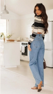 Women's blue high-waisted wide-leg denim jeans shown in a bright home lifestyle setting