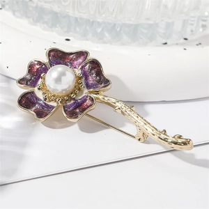 Floral purple enamel daisy brooch with pearl center on a white textured background