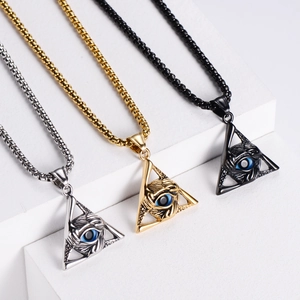 Makroansicht von Punk Dreieck Evil Eye Anhängern in Gold, Silber und Schwarz