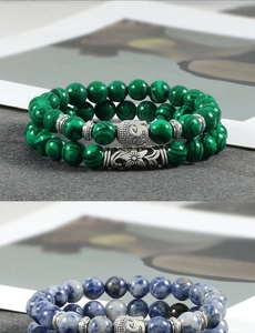 Detail of beaded bracelets with malachite and sodalite stones and silver Buddha charms