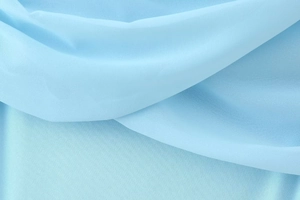 Detail of light blue sheer mesh fabric with soft folds on a sleeveless bodycon dress