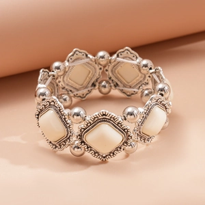 Detail of vintage geometric acrylic stretch bracelet with silver-tone metal and cream inserts