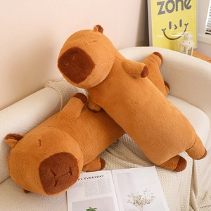 Close-up of cute brown capybara plush body pillows on a cozy white sofa background