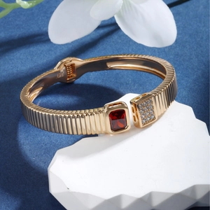 Luxury gold-plated hinged bangle featuring a square red gemstone and pavé diamonds