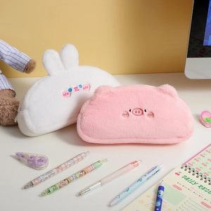 Detail of plush cartoon pig and rabbit pencil cases with soft furry texture and embroidery
