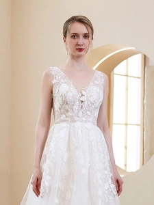 Close-up of elegant V-neck lace embroidery and floral patterns on white bridal gown