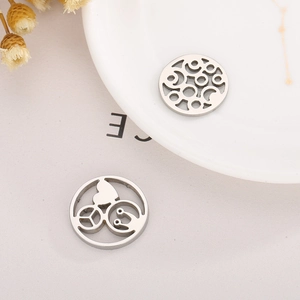 Detail of silver hollowed circular pendants with heart, peace sign, and smiley face motifs