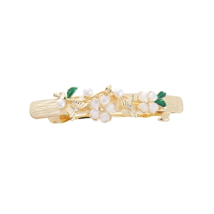 Elegante fermaglio floreale con petali bianchi, farfalle dorate e perle su sfondo bianco