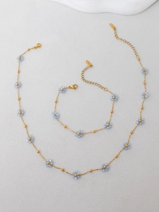 Detailed view of light blue beaded flower necklace and bracelet set with S.STEEL stamp