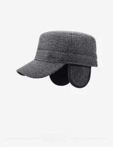 Detail of grey wool tweed winter hat showing thick texture and metal logo emblem