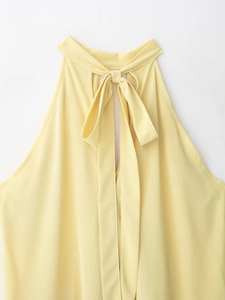 Detail of the elegant pale yellow halter neck top featuring a chiffon bow tie at the back