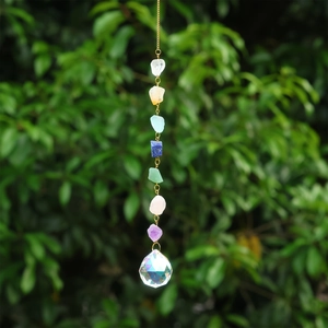 Détail d'un attrape-soleil en cristal avec sept pierres de chakra et boule à facettes