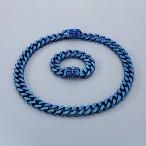 Blue Cuban link chain necklace and bracelet set with skull clasp detail on grey background