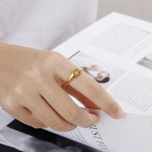 Golden stainless steel oval ring with an eight-pointed star worn by a model