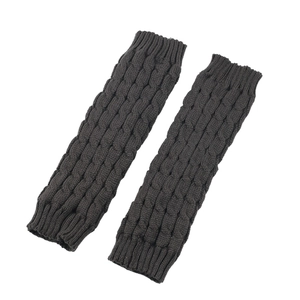 Detailed view of dark grey cable knit leg warmers with ribbed cuffs and textured wool