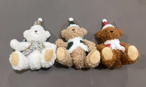 Detailed view of plush Christmas teddy bears in brown and white with festive hats