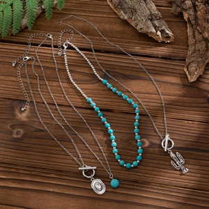 Detail of layered turquoise beaded necklaces with retro cactus and oval bull head pendants