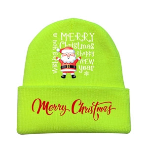 Detail of neon green knitted Christmas beanie with festive Santa print and text
