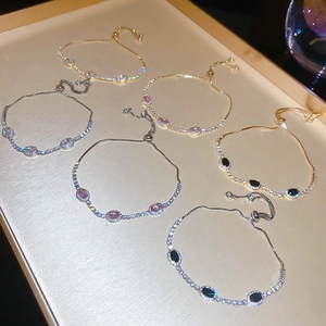 Close-up of adjustable zircon bracelets in gold and silver with various gemstones