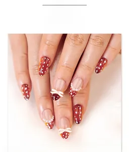 Faux ongles amande courts marron avec pois blancs et nœuds décoratifs en relief