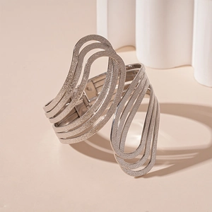 Detail of silver wavy multilayer cuff bracelet with a modern geometric open design