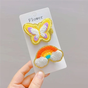 Detail of plush butterfly and rainbow hair clips with golden glitter edges for girls