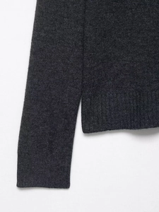 Detail of charcoal grey knit cardigan featuring ribbed cuffs and high-quality wool texture