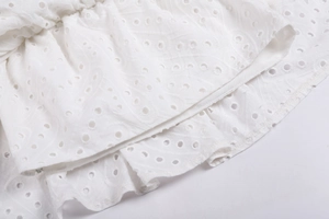 Gros plan sur tissu en dentelle anglaise blanche avec motifs brodés ajourés délicats