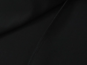 Dettaglio macro della cucitura piatta su tessuto nero elasticizzato del top