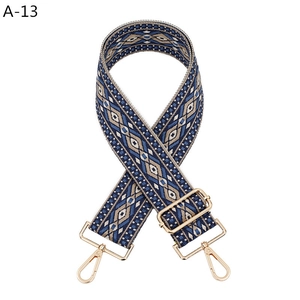 Detail of blue and brown geometric jacquard purse strap with gold lobster clasps
