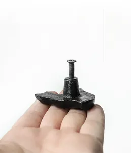 Detail of black cast iron cat cabinet handle with screw mounting hardware for furniture