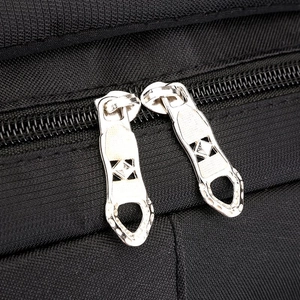 Close-up of durable silver metal dual zippers on black travel backpack texture