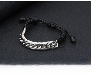 Close-up of adjustable Cuban link chain bracelet with black woven rope and silver finish